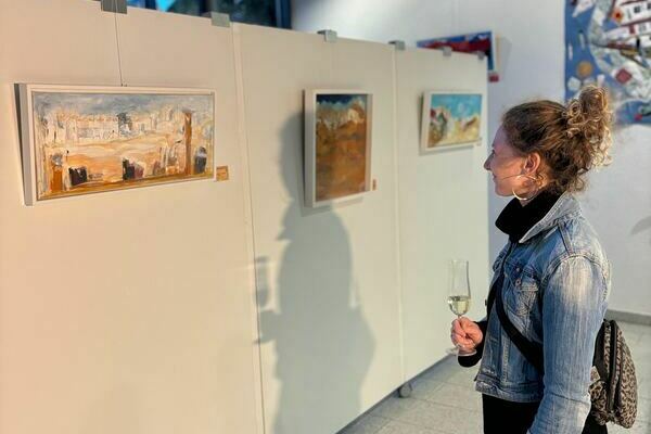 Besucherin bewundert das Bild "Lost in desert", 2024, Acryl auf Leinwand, Elv. A. Str�uber